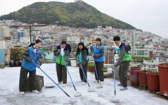 에어부산ㆍ진에어ㆍ에어서울 임직원이 지난 14일 부산 서구 남부민동 일대 쿨루프 활동에 참여해 옥상에 차열 페인트를 도포하고 있다. /사진: 에어부산 제공