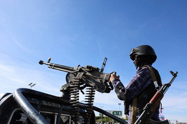 지난달 27일(현지시간) 미국·이스라엘과 이란 간 갈등이 이어지는 가운데 예멘 사나에서 열린 이란 지지 집회 현장에서 후티 경찰 대원이 순찰 차량에 장착된 기관총을 운용하고 있다. (사진=로이터)