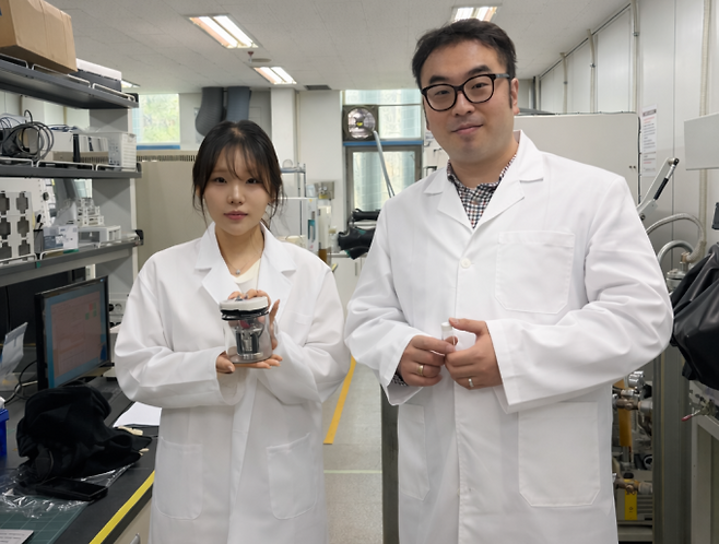 김태효 수석연구원(오른쪽)과 배진영 인턴(왼쪽)이 개발한 전해질을 적용한 전고체 전지 셀을 들고 있다. 생기원 제공