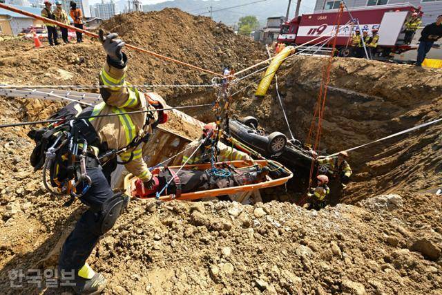 15일 경기 하남시 교산 공공주택지구에서 열린 2026년 중대재난대응 유관기관 합동훈련에서 경기119특수대응단 특수구조팀원들이 붕괴사고(싱크홀)를 가정한 구조 훈련을 하고 있다. 사진은 구조대원이 하이라인 로프시스템을 활용해 매몰자를 구조하는 모습. 하남=강예진 기자