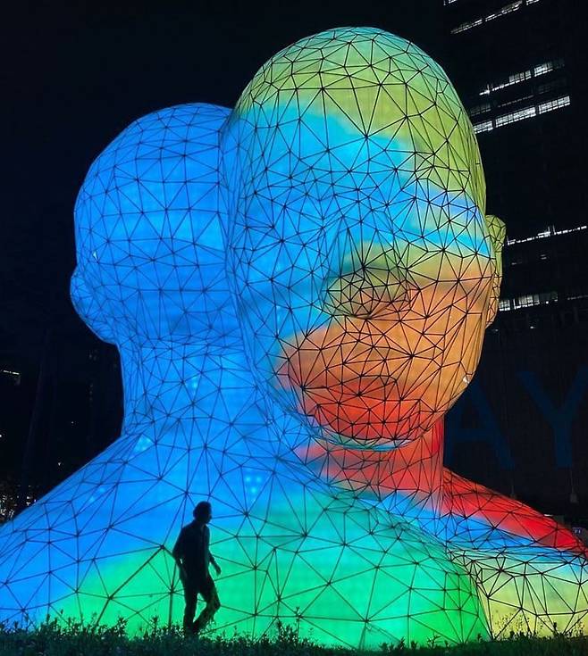 2008년 서울 상암동 디지털미디어시티(DMC) 조형물 공모전에서 대상을 받아 2010년 완성한 높이 12m의 THEY. 작품 앞 검은 실루엣이 이진준 교수다. [사진 이진준]