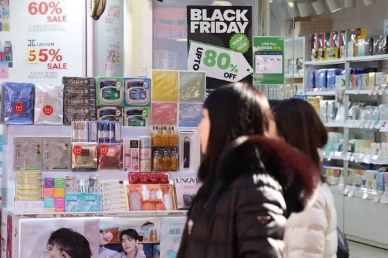 지난해 12월 21일 서울 명동 거리에서 외국인들이 화장품을 둘러보고 있다. 연합뉴스