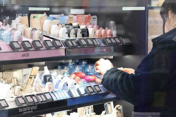 지난해 12월 21일 서울 명동 거리에서 외국인들이 화장품을 고르고 있다. 연합뉴스