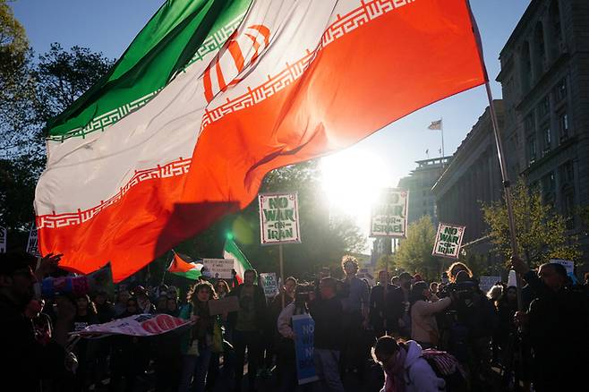 지난 7일(현지시간) 미국 워싱턴DC 백악관 앞에서 시위대가 이란 깃발을 들고 있는 모습. 도널드 트럼프 미국 대통령은 이날 이란과 2주 간의 휴전에 동의했다고 밝혔다. [로이터 = 연합뉴스]