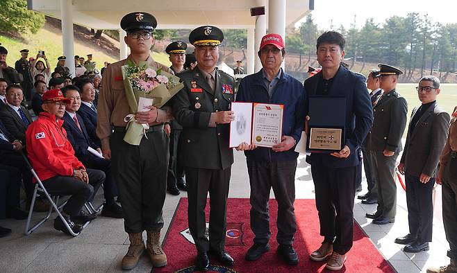 주일석 해병대사령관(왼쪽 두번째)이 15일 경기도 화성시 해병대사령부에서 열린 창설 77주년 기념행사에서 해병대 최초로 4대(代) 해병을 배출한 김준영 이병(왼쪽) 가족에게 병역명문가 패를 전달한 뒤 기념촬영을 하고 있다. 김 이병 집안은 세상을 떠난 증조할아버지 김재찬씨부터 할아버지 김은일씨(왼쪽 세번째), 아버지 김철민씨(〃 네번째)가 해병대에서 복무했다. 해병대 제공