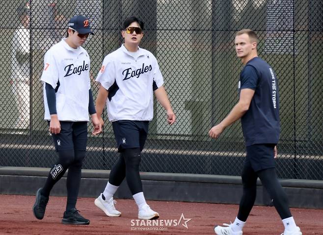 한화 김서현(가운데)이 15일 대전 한화생명볼파크에서 열린 2026 신한 SOL KBO리그 삼성 라이온즈전을 앞두고 새로 마루미를 맡게 된 잭 쿠싱(오른쪽)과 스쳐지나고 있다. /사진=강영조 선임기자