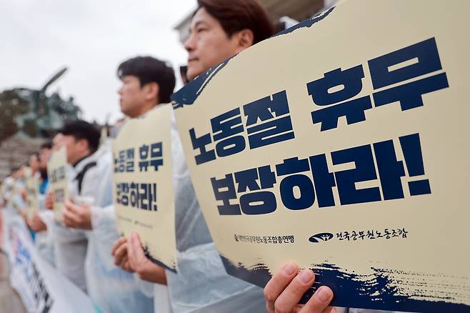 지난달 18일 국회 본청 앞 계단에서 전국공무원노동조합과 대한민국공무원노동조합총연맹이 연 공무원 노동절 휴무 쟁취 기자회견에서 참석자들이 손팻말을 들고 있다. 연합뉴스