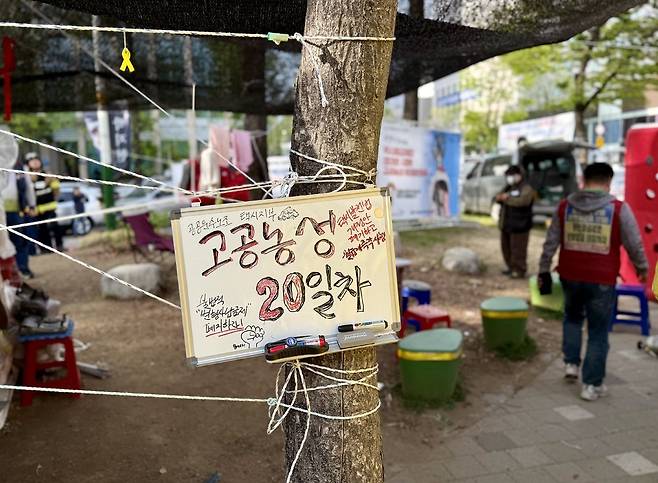▲ 17일 오후 인천 남동구 고공농성장 옆 천막 농성장에 '공공운수노조 택시지부 고공농성 20일차'를 알리는 안내판이 설치돼 있다.