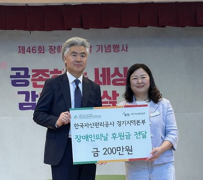 배원섭(왼쪽) 한국자산관리공사 경기지역본부장이 17일 제46회 장애인의 날을 기념해 권미정 수원시광교장애인주간이용시설 원장에게 기부금을 전달한 후 기념촬영을 하고 있다.