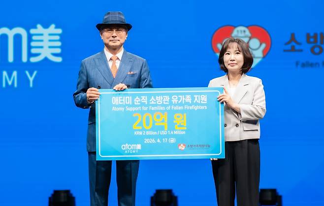 박한길 애터미 회장과 박현숙 소방가족희망나눔 가족대표가 기념사진을 찍고 있다.(애터미 제공)