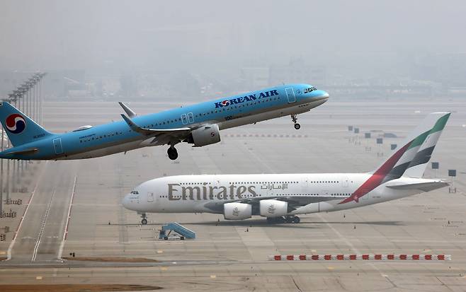 인천국제공항에서 대한항공 여객기가 이륙하고 있다. 아래에 UAE의 에미레이트항공사 여객기가 보인다. 연합뉴스