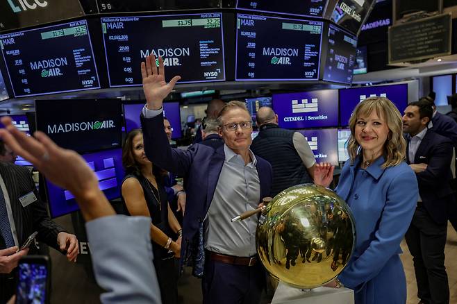 매디슨 인더스트리스의 래리 기스(가운데) 최고경영자(CEO)가 16일(현지 시간) 미국 맨해튼 뉴욕증권거래소(NYSE)에서 열린 기업공개(IPO) 행사에서 손을 흔들고 있다. 로이터연합뉴스