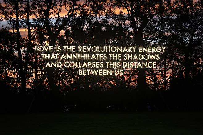 ‘광고판을 시(詩)로 파괴하는 예술가’ 로버트 몽고메리의 야외 설치 작품. “사랑은 어두움을 소멸하고 우리 사이의 거리를 무너뜨리는 혁명적 에너지다”라는 문구로 전시가 던진 질문의 해법이 ‘사랑’임을 암시한다. /포도뮤지엄