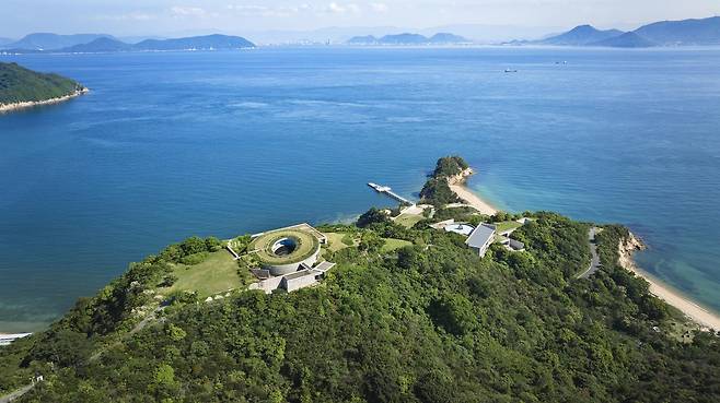 세토내해의 짙푸른 바다 위, 울창한 숲 사이로 안도 다다오의 건축이 어우러진 나오시마의 풍경. ‘나오시마 예술의 탄생’은 쇠락해 가던 이 섬을 현대미술의 성지로 바꾼 나오시마 프로젝트의 아트 디렉터가 15년의 경험을 처음으로 기록한 책이다. 알에이치코리아 제공 ⓒ Benesse Art Site Naoshima