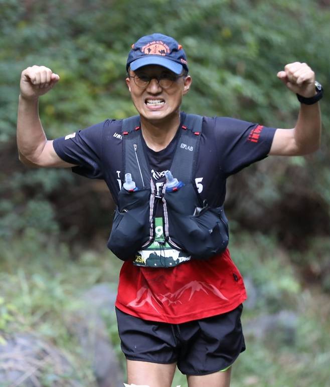 원윤식 네이버클라우드 전무가 한 트레일러닝 대회에서 질주하며  양팔을 들어올리고 있다. 20여년 전인 30세 초반, 심근경색으로 쓰러지고 나서부터 달리기 시작한 원 전무는 산을 달리는 트레일러닝 160km도 거뜬히 완주하는 ‘철각’이 됐다. 원윤식 전무 제공