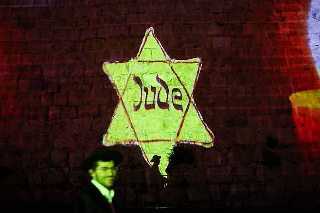 13일(현지시간) 이스라엘 홀로코스트 추모일(욤 하쇼아)을 하루 앞두고 예루살렘 구시가지에서 시민들이 성벽 옆을 걷고 있다. 매년 열리는 이 추모일은 제2차 세계대전 당시 나치 독일과 그 동맹국에 의해 학살된 약 600만 명의 유대인을 기리는 날이다. EPA=연합뉴스