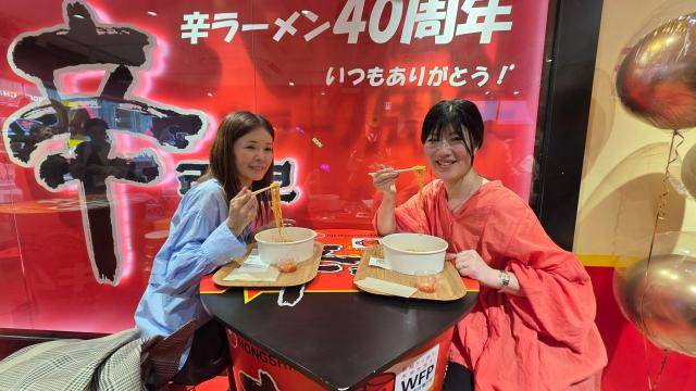 왼쪽부터 도쿄 출신 도야마씨와 아키코씨가 신라면 툼바를 먹으며 포즈를 취하고 있다. [사진=김현아 기자]