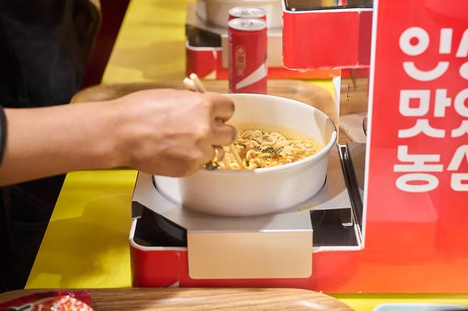 15일 도쿄 하라주쿠 다케시타 거리에 있는 '신라면분식' 방문객들이 일명 '한강 라면' 라면 즉석조리기를 체험하고 있다.(사진제공=농심)