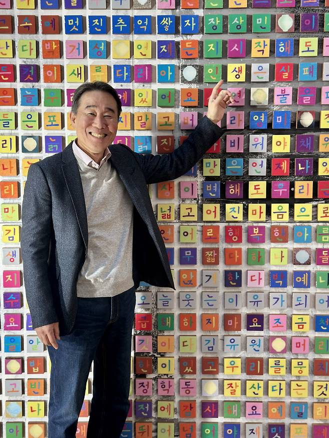 김천수 전 뉴욕한국문화원장이 문화원 ‘한글벽’ 앞에서 미소 짓고 있다. (사진=김상윤 특파원)