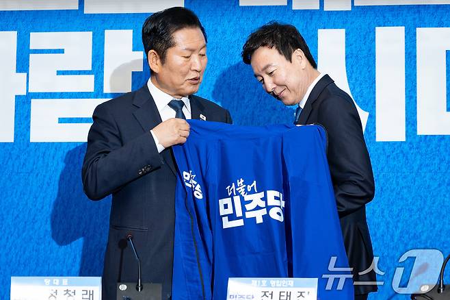 정청래 더불어민주당 대표가 17일 서울 여의도 국회에서 열린 제1차 인재영입식에서 전태진 변호사에게 당 점퍼를 입혀주고 있다. 2026.4.17 ⓒ 뉴스1 유승관 기자