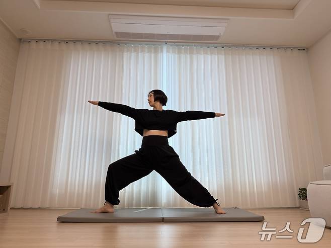 김유빈 요가강사가 임신부에 좋은 전사자세2를 보여주고 있다. 다리를 약 120cm로 넓게 벌린 후 한쪽 발을 90도 바깥으로 틀고 그 방향으로 무릎을 열어 골반을 연다. 양팔을 옆으로 수평으로 벌리고 시선은 구부린 무릎 쪽 손끝을 향한다. 치골, 배꼽, 가슴 중앙, 미간이 같은 선상에 있도록 정렬하고 고개만 돌린다. 하체 근력과 골반·척추의 안정성, 유연성 향상에 도움을 준다.ⓒ 뉴스1 서장원 기자