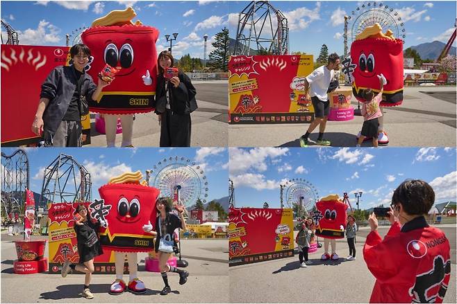 후지큐 하이랜드 방문객들이 신라면 캐릭터 '신'(SHIN)과 기념사진을 찍고 있다.(농심 제공)