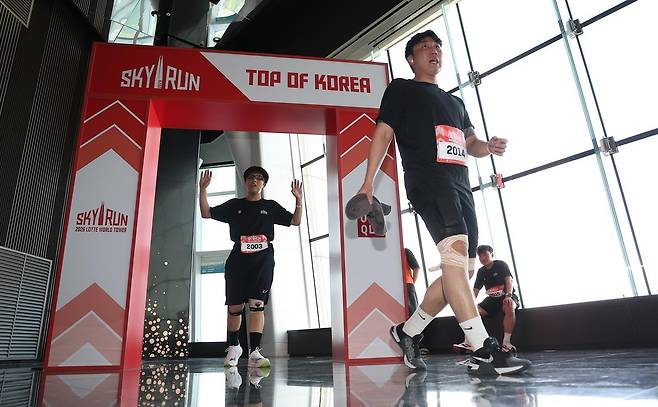 19일 서울 송파구 롯데월드타워에서 열린 수직 마라톤 대회 ‘2026 롯데월드타워 스카이런’ 행사에서 참가자들이 결승선을 지나고 있다.사진공동취재단