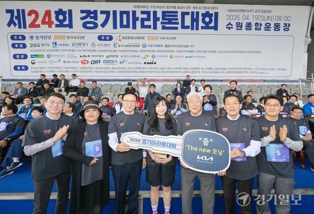 제24회 경기마라톤대회에서 경품행사 1등인 기아자동차 더뉴모닝 승용차의 당첨자가 된 윤희숙씨와 내빈들이 함께 기념촬영을 하고 있다. 윤원규기자