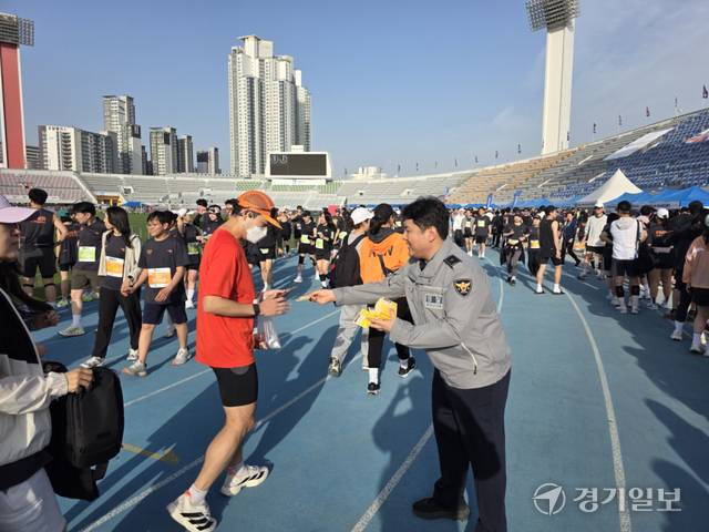 경기마라톤대회가 열린 수원종합운동장에서 경기남부경찰청 형사과 소속 이영광 경장이 마라톤 참가자에게 보이스피싱 예방 문구가 담긴 선크림을 나눠주며 홍보 활동을 하고 있다. 오종민기자