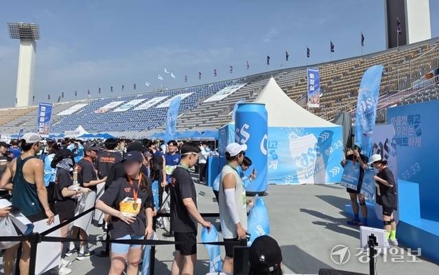 경기마라톤대회가 열린 수원종합운동장에서 참가자들이 오비맥주 ‘카스 라이트’ 기록 체크 부스에서 기념사진을 촬영하기 위해 줄을 서 있다. 오종민기자