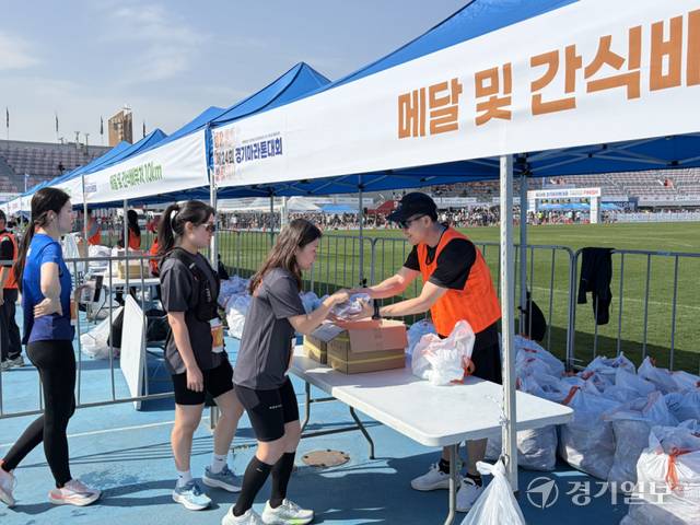 19일 오전 수원종합운동장에서 열린 ‘제24회 경기마라톤대회’ 하림 라면 간식 배부 부스에서 완주자들이 간식을 받아 들고 있다. 이실유 기자