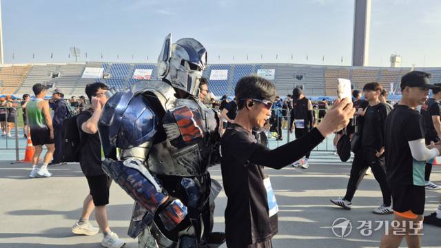 ‘경기런페스타 코스프레’ 이벤트가 열린 19일 ‘제24회 경기마라톤대회’ 현장에서 한 참가자가 트랜스포머 시리즈의 로봇 분장을 한 참가자와 함께 기념사진을 촬영하고 있다. 금유진기자
