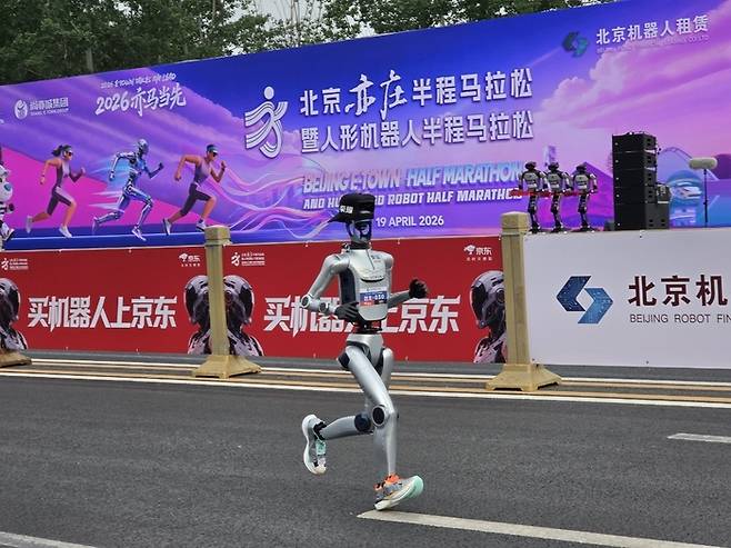 19일 중국 베이징시 이좡에서 개최된 ‘제2회 휴머노이드 로봇 하프마라톤 대회’에 참가한 한 로봇이 모자를 쓰고, 운동화를 신은 채 달리고 있다. [연합뉴스]