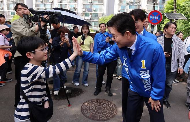정원오 더불어민주당 서울시장 후보가 19일 서울 노원구 불암산 힐링타운에서 열린 '불암산 철쭉제' 현장에서 한 어린이와 손을 맞대며 인사하고 있다.  한주형 기자