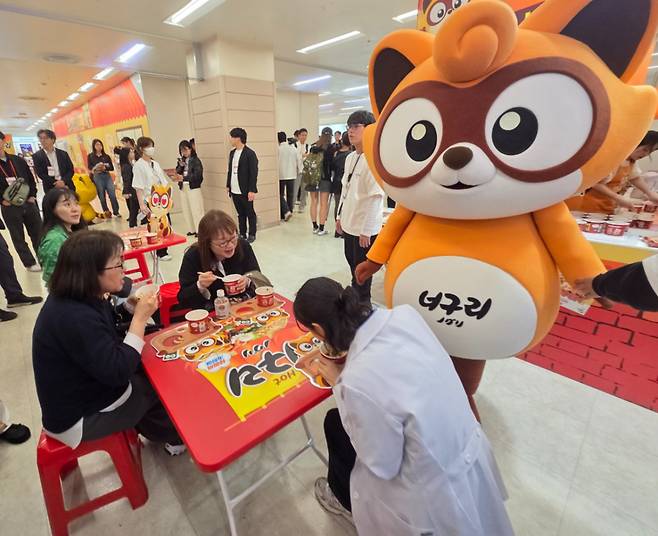 도쿄 이케부쿠로 선샤인 시티에서 개막한 '2026 코리아 엑스포 도쿄' 부스에서 방문객들이 너구리를 시식하고 있는 모습./사진=차현아 기자.
