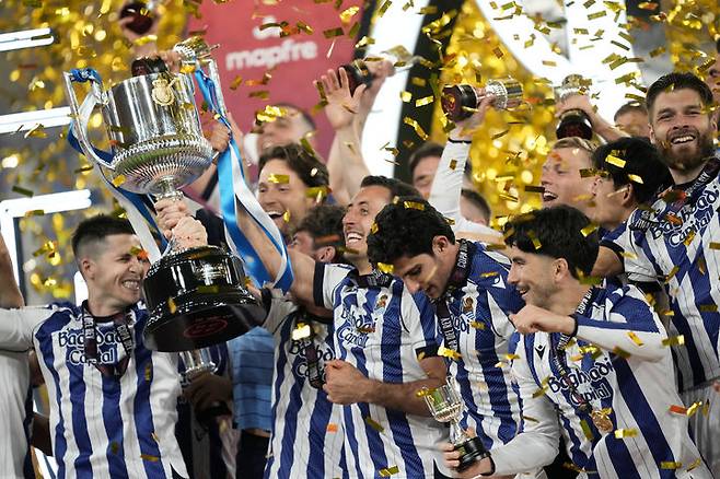 [세비야=AP/뉴시스] 레알 소시에다드 선수들이 18일(현지 시간) 스페인 세비야의 에스타디오 라 카르투하 데 세비야에서 열린 2025-26 스페인 코파 델 레이(국왕컵) 정상에 올라 트로피를 들고 환호하고 있다. 레알 소시에다드는 결승에서 아틀레티코 마드리드와 2-2 무승부를 기록해 승부차기 끝에 4-3으로 승리하고 우승컵을 들어 올렸다. 2026.04.19.