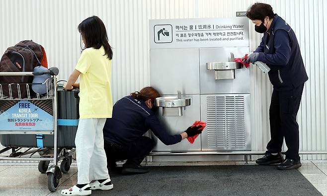 인천국제공항 제2 여객터미널 음수대에서 이용객들이 깨끗한 물을 마실 수 있게 청소하고 있다.