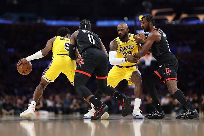 LA 레이커스의 르브론 제임스(오른쪽 둘째)가 19일 미국 LA에서 열린 휴스턴 로키츠와의 NBA(미 프로농구) 플레이오프 1라운드 첫 경기에서 드리블하는 아들 브로니 제임스(맨 왼쪽)를 위해 상대 수비를 막고 있다. 아버지와 아들이 함께 플레이오프 경기에 나선 것은 NBA 역사상 처음이다. /AFP 연합뉴스