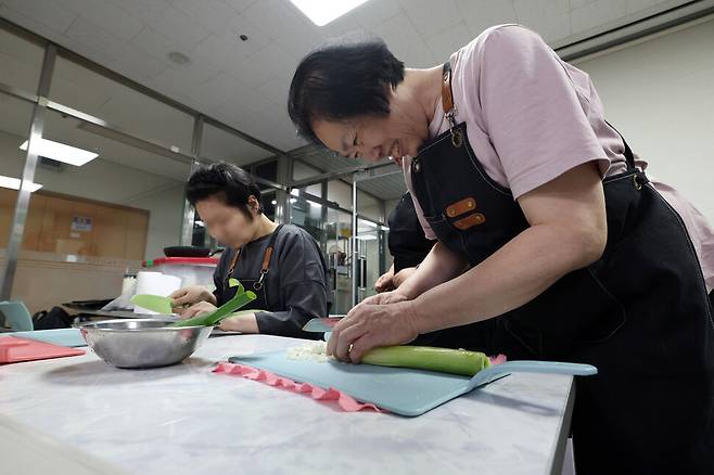 허정미씨가 지난 15일 오후 서울 노원구 다운복지관에서 ‘중요한 사업’ 수업에 참여해 대파를 다지며 웃고 있다. 김영원 기자 forever@hani.co.kr