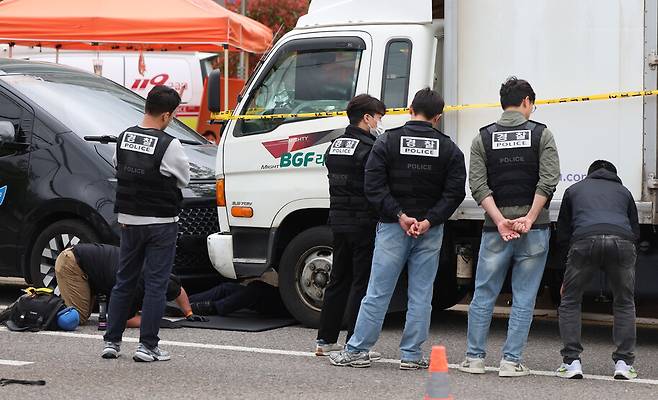 경찰이 20일 경남 진주시 정촌면 씨유 진주물류센터에서 화물연대 관계자 1명이 숨지고, 3명이 다친 사고와 관련해 현장에서 사고 차를 조사하고 있다. 연합뉴스