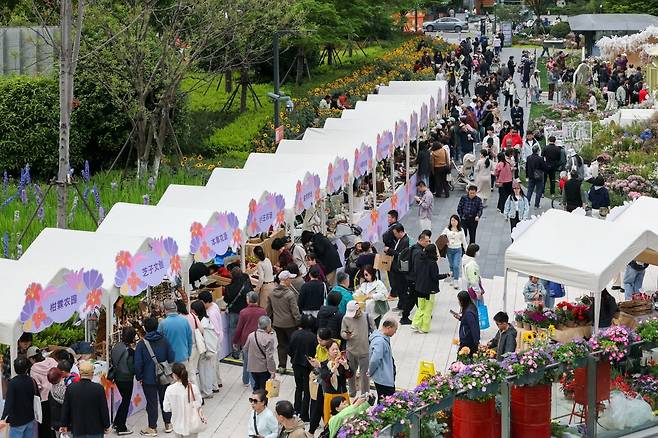 상하이, 2026년 4월 18일 (신화통신) -- 2026년 4월 18일, 중국 동부 상하이 징안구에서 열린 꽃 박람회를 방문한 관람객들. 2026 상하이 국제 꽃 박람회가 토요일 개막했으며, 시내 전역의 2개 주요 행사장, 10개 부대 행사장 및 다수의 전시 장소에서 행사가 열리고 있다. 연합뉴스