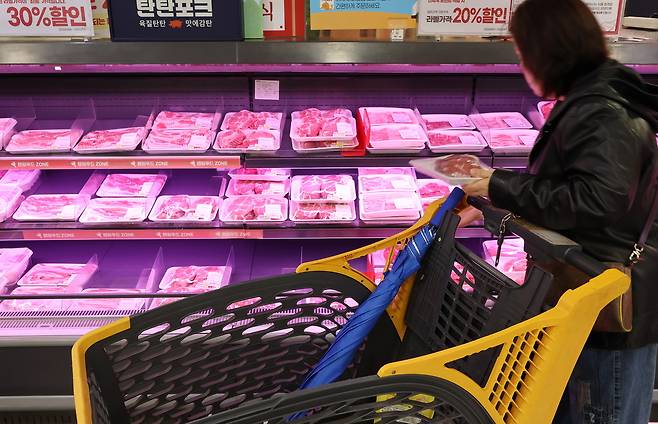 한 시민이 서울의 한 대형마트에서 돼지고기를 고르고 있다. [연합]