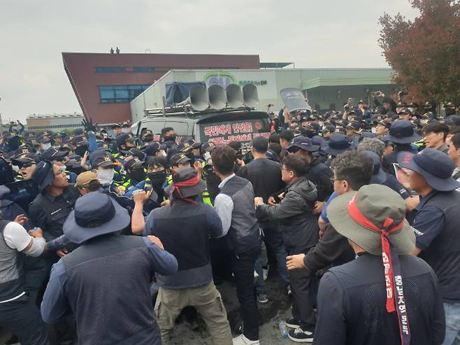 20일 오후 경남 진주시 정촌면 BGF로지스 진주센터에서 화물연대 관계자가 센터 입구로 진입하려는 과정에서 경찰과 대치하고 있다. 연합뉴스