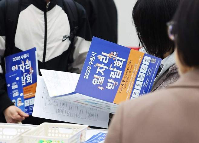 지난 9일 경기 수원시 영통구 수원컨벤션센터에서 열린 ‘2026 수원시 일자리 박람회’에서 구직자가 안내책자를 살펴보고 있다. 연합뉴스