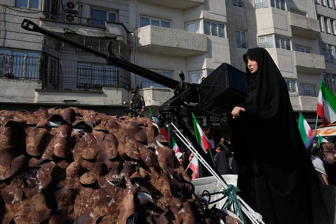 총구 겨눈 이란 여성 - 이란 이슬람혁명수비대(IRGC) 산하 바시지 민병대 소속 여성 대원이 지난 17일(현지시간) 테헤란에서 열린 최고지도자 지지 집회에서 기관총을 들고 정면을 조준하고 있다. 이날 호르무즈 해협 통행 제한을 일시 해제한 이란은 미국이 대이란 봉쇄를 풀지 않자 다음날 해협을 재봉쇄했다. 테헤란 AP 연합뉴스