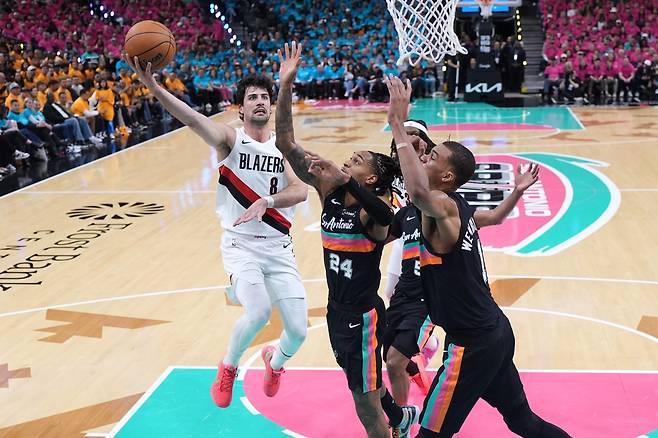 포틀랜드 데니 아브디야(오른쪽)가 20일(한국시간) 프로스트뱅크 센터서 열린 샌안토니오와 NBA&nbsp;PO 1라운드 1차전서 데빈 바셀(가운데), 빅토르 웸반야마의 볼로킹을 피해 레이업슛을 시도하고 있다. 샌안토니오｜AP뉴시스