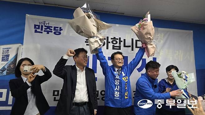 20일 민경선 더불어민주당 고양특례시장 후보(가운데)가 민주당 고양시장 결선에서 최종 승리를 확정지은 후 꽃다발을 든 양손을 번쩍 치켜올리고 있다. 김태훈 기자