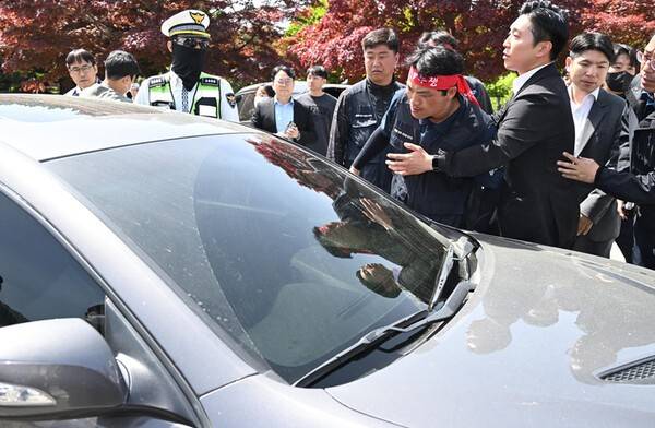 21일 화물연대 소속 노동자 등이 희생자 영정사진을 들고 경남경찰청 앞에서 진주 예하리 노동자 사망 관련 CU BGF로지스와 경찰을 규탄하는 화물연대 기자회견을 했다. 지나가는 차량 운전자가 창밖으로 욕설을 내뱉자 인근 노동자들이 차를 막고 항의하고 있다. /김구연 기자