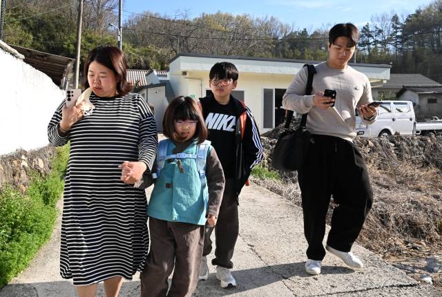 진휘준 기자가 함양군 목현마을에서 금반초 최현서·최유정 남매와 통학버스를 타기 위해 이동하고 있다./성승건 기자/