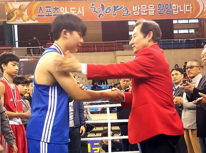 김재한씨가 지난해 열린 전국소년체육대회에서 수상 선수에게 매달을 목에 걸어주며 격려하고 있다. <김재한씨 제공>